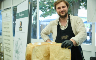 Produttore di parmigiano reggiano biologico allo stand durante Officinalia