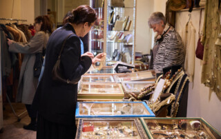 00001-Next-Vintage-Belgioioso-gioielli-accessori-vintage Visitatrice osserva gioielli e accessori vintage esposti in vetrina al Castello di Belgioioso