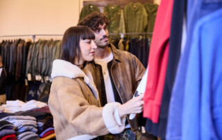 00009-Next-Vintage-Belgioioso-visitatori-selezione-capi Coppia di visitatori osserva capi vintage tra gli stand della mostra