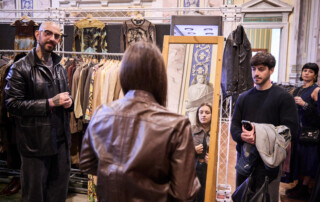 00010-Next-Vintage-Belgioioso-area-specchio-esposizione Visitatori davanti a uno specchio in un’area espositiva di abbigliamento vintage