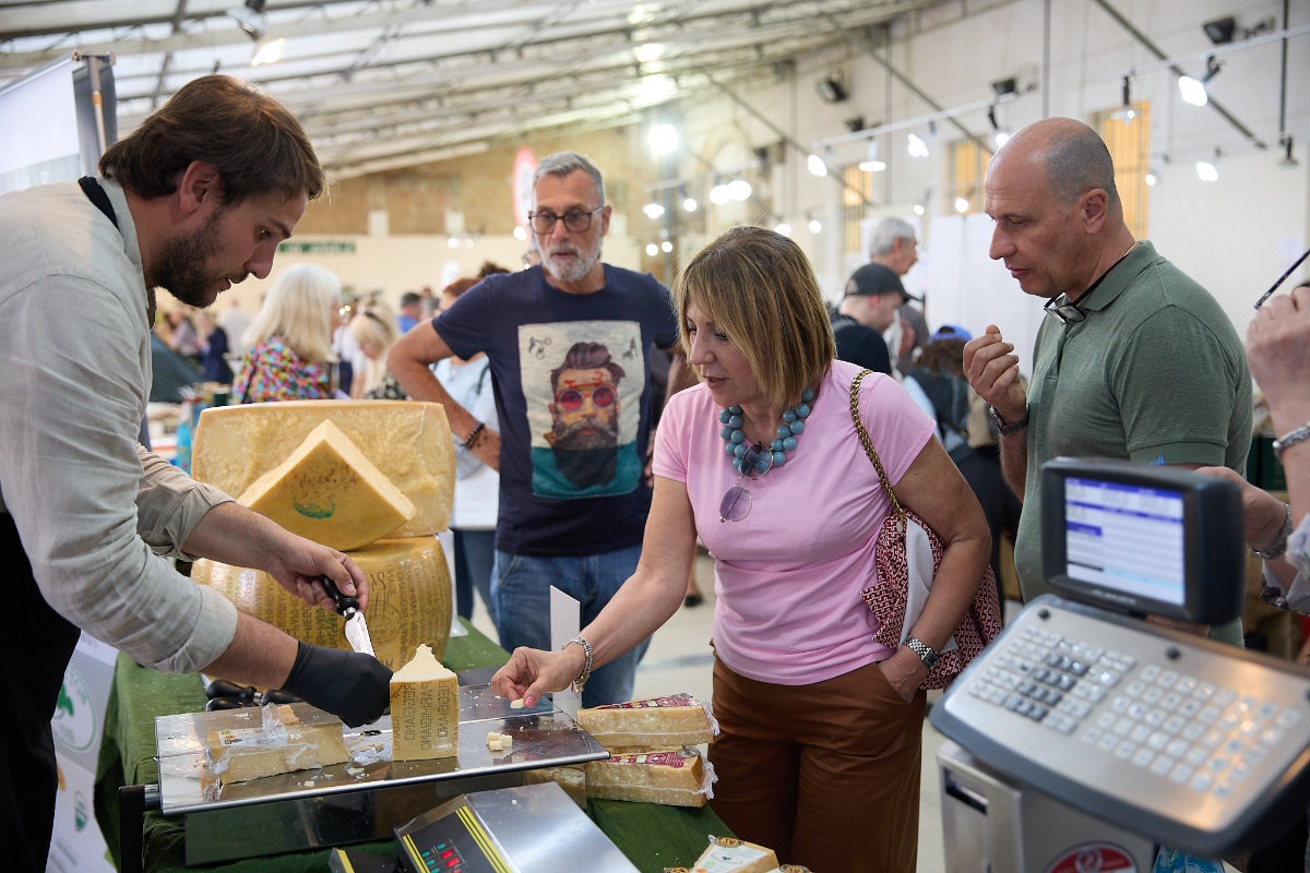 Produttori cibo biologico con visitatori che assaggiano a officinalia belgioioso