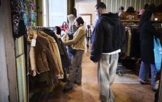 Visitatori alla mostra Next Vintage mentre scelgono capi d’abbigliamento vintage al Castello di Belgioioso